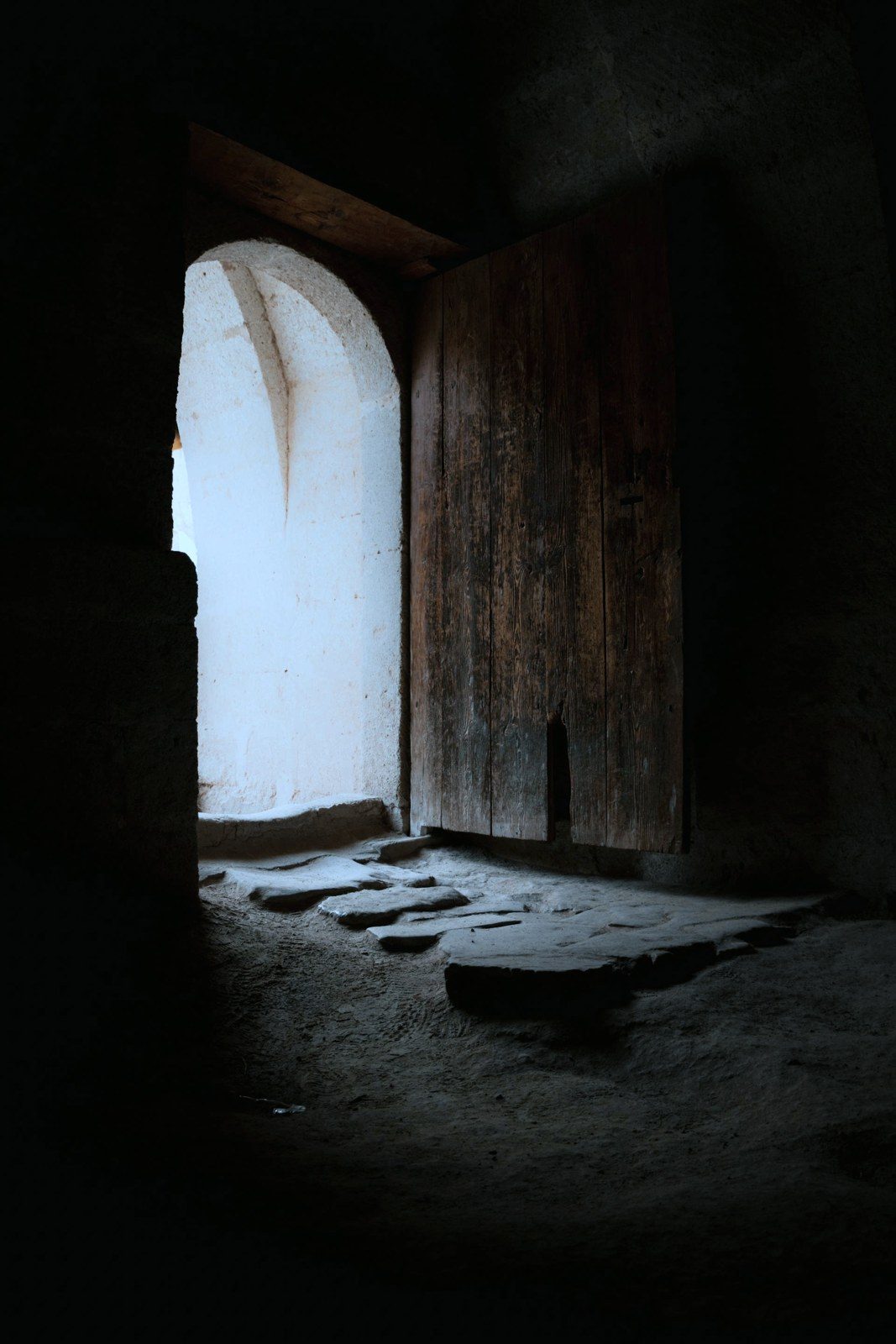 Light falling through an ancient doorway onto a worn stone floor